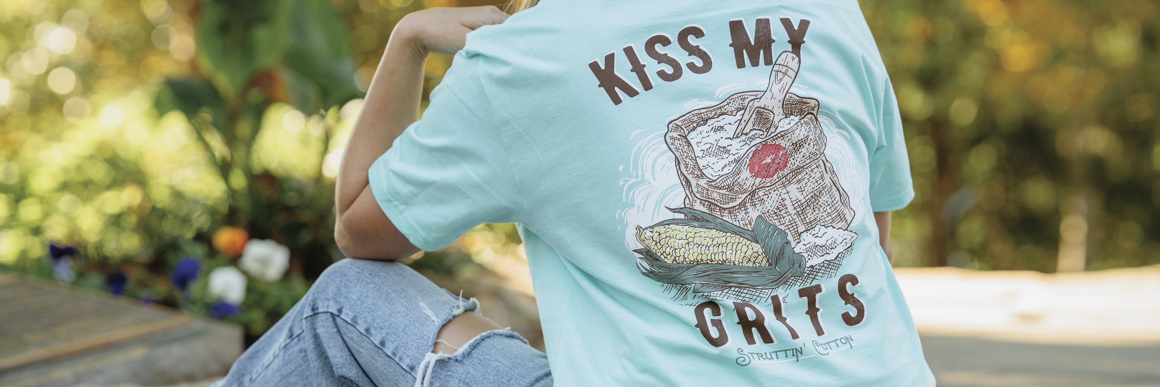 woman sitting in a Struttin Cotton "Kiss my Grits" shirt